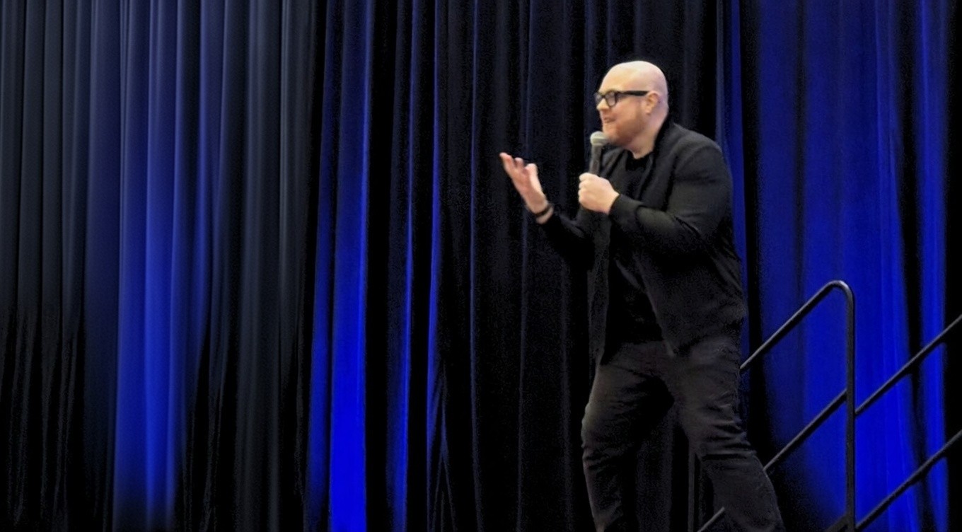 Dan Fitzpatrick speaking on a blue-lit stage