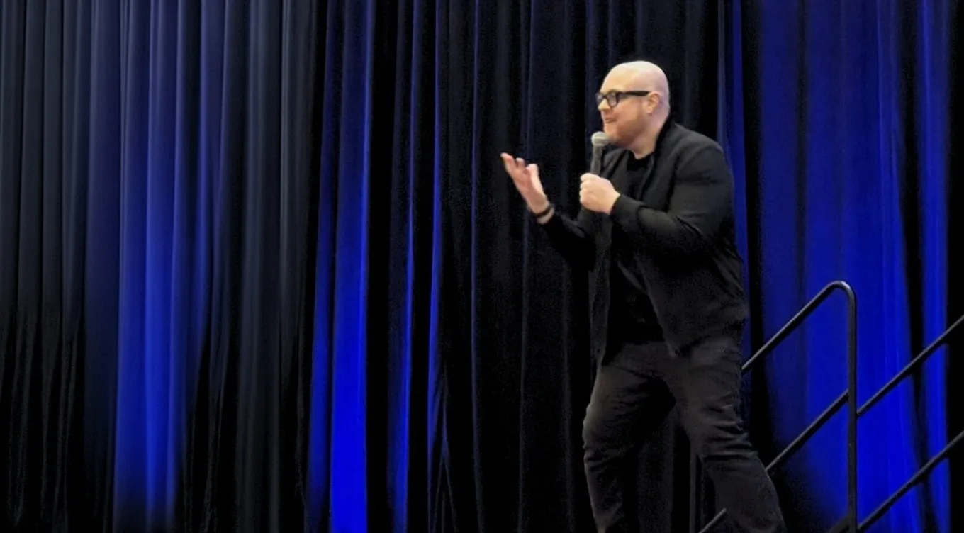 Dan Fitzpatrick speaking on a blue-lit stage