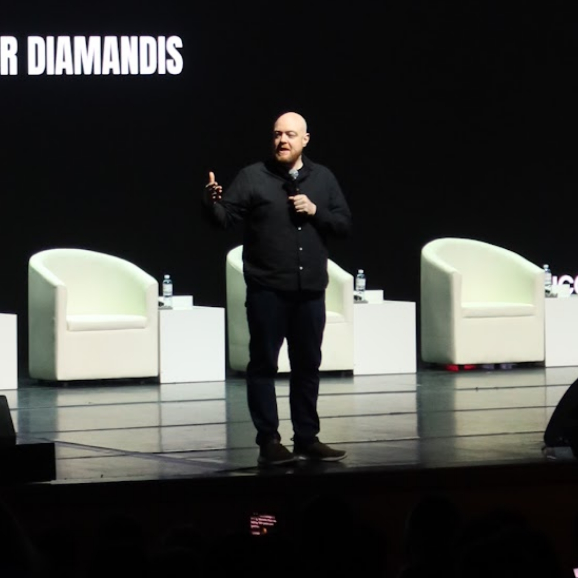 Dan Fitzpatrick speaking on stage at an event with Peter Diamandis